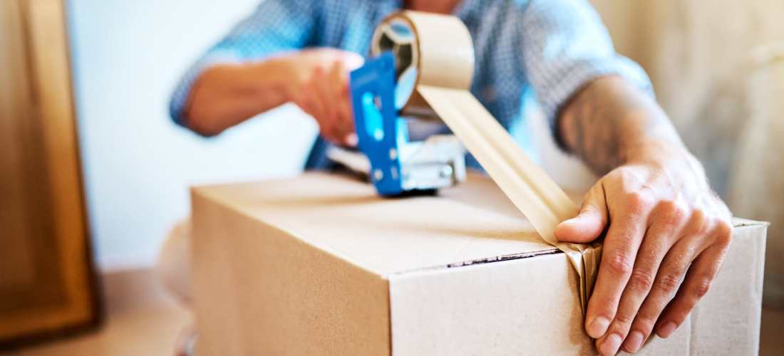 Preparing cardboard box for storage or moving at Storage Hub - Clearwater - Ulmerton in Clearwater, Florida