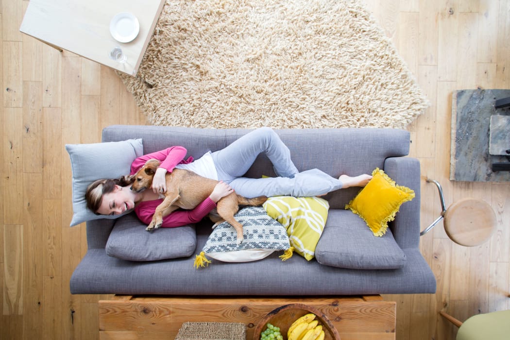 Resident cuddling her puppy in her modern living room at Casanova at Monterey Bay in Monterey, California