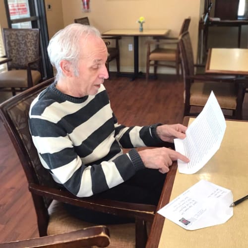 Resident opening a letter at Oxford Glen Memory Care at Grand Prairie in Grand Prairie, Texas