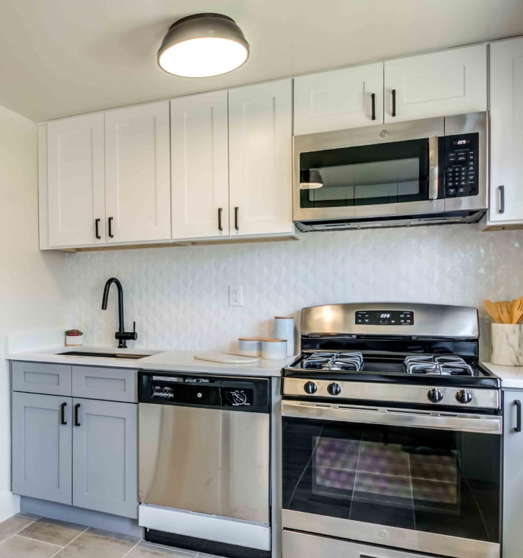 Modern kitchen with a custom tile backsplash and stainless-steel appliances in a model home at Haven New Providence in New Providence, New Jersey