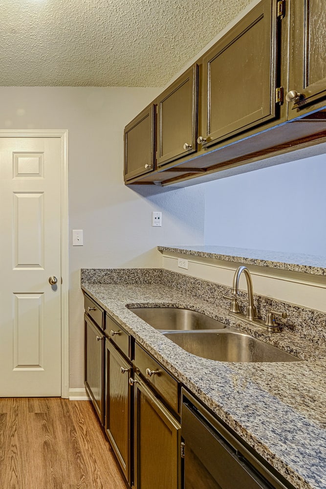 Modern kitchen with granite counters and wood style floor at Hunters Point in Zionsville, Indiana