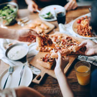 Friends enjoying a pizza dinner at Capri Creek Apartments in Petaluma, California