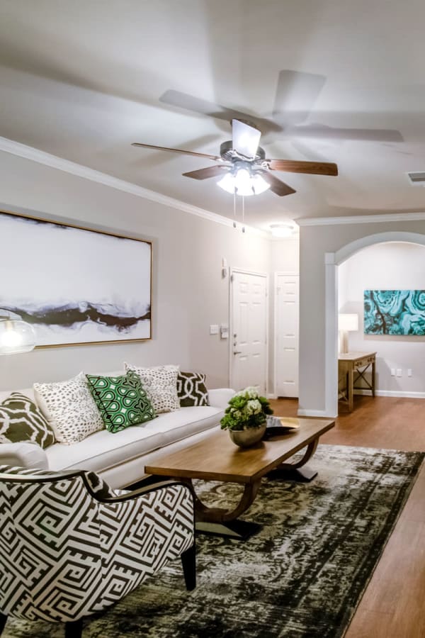 Well-decorated living area with a ceiling fan in a model apartment at Sonterra Heights in San Antonio, Texas