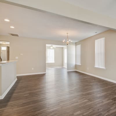 An open living room with wood flooring in a home at The Village at Whitehurst Farm in Norfolk, Virginia