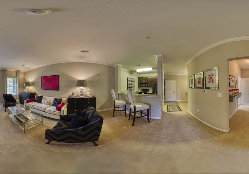 Fishbowl of spacious living room, kitchen, and dining room with cozy chair, couch, bar chairs, and carpeting at Glass Creek in Mt Juliet, Tennessee