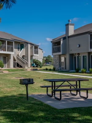 Grassy area with picnic bench and bbq at Aspen Park Apartments in Wichita, Kansas