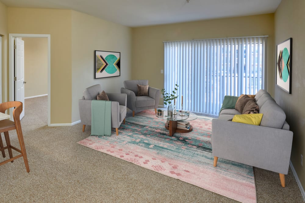 A living room complete with patio access at The Crossings at Bear Creek Apartments in Lakewood, Colorado