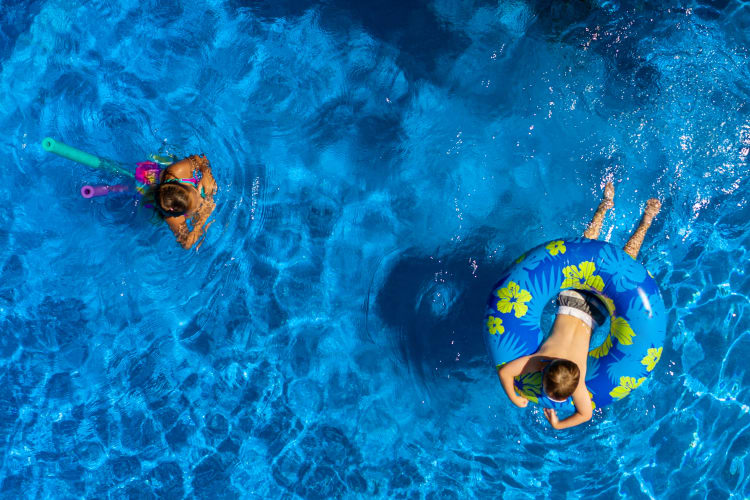 Young residents swimming in the resort-style pool at Executive Apartments in Miami Lakes, Florida