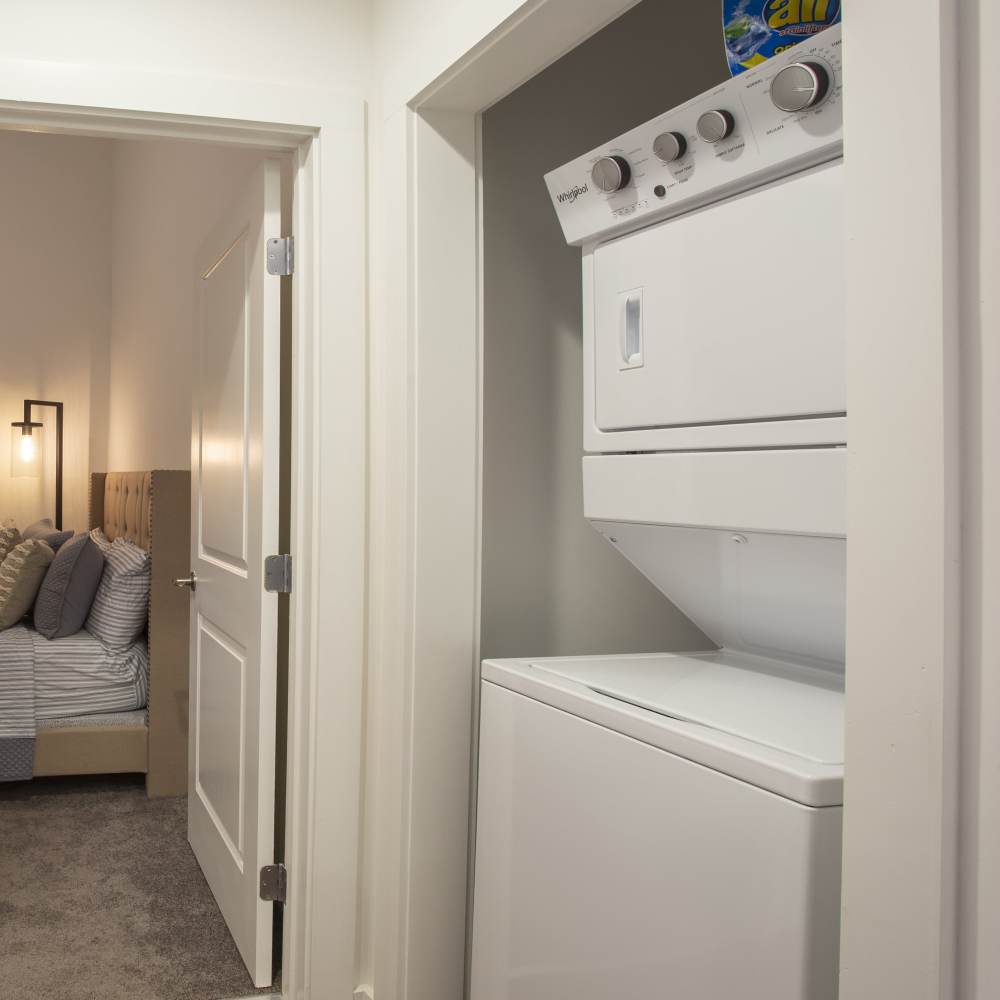 Stacked washer and dryer beside the bedroom at Lofts at Inman Mills in Inman, South Carolina