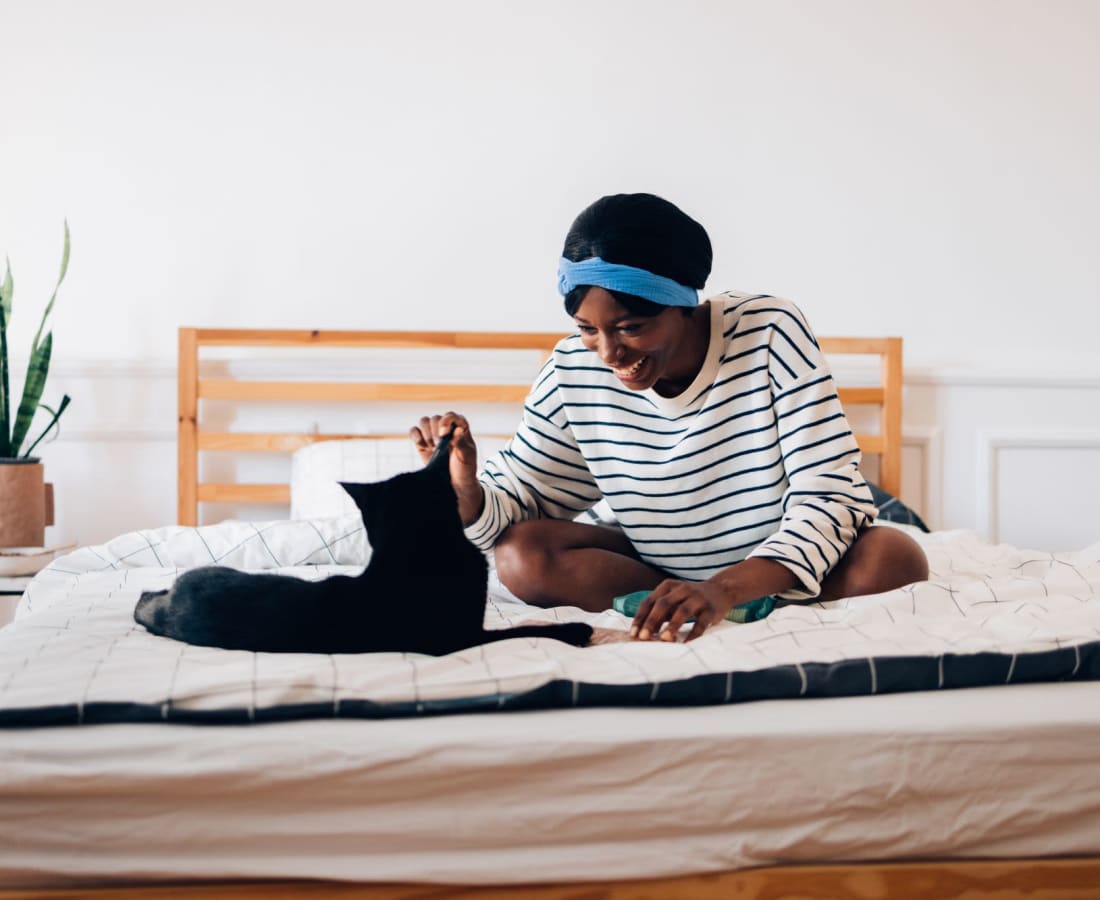 A resident sitting on her bed with her cat at Haven Hill Exchange in Atlanta, Georgia