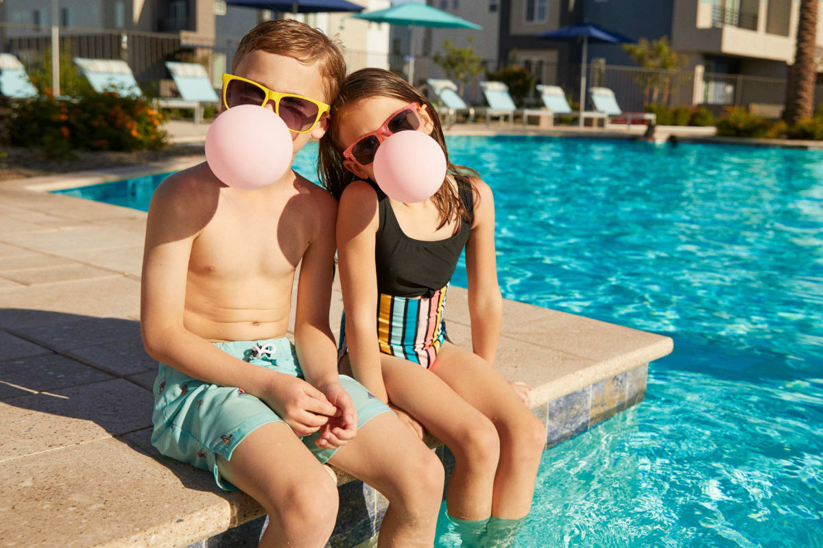 Two kids sitting by the pool at BB Living at Civic Square in Goodyear, Arizona