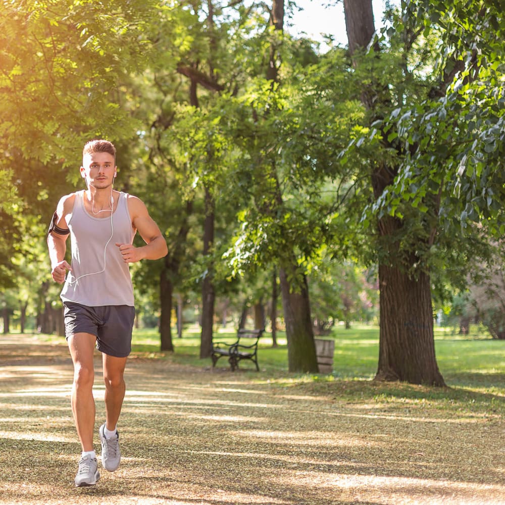 Resident jogging through the verdant neighborhood at Oaks White Rock in Dallas, Texas