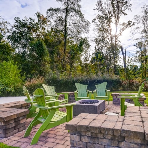 Outdoor patio, fireplace and chairs at Creekside at Greenlawn Apartment Homes in Columbia, South Carolina