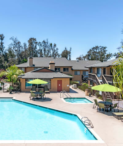 Refreshing swimming pool with lounge areas and umbrellas at Hillside Terrace Apartments in Lemon Grove