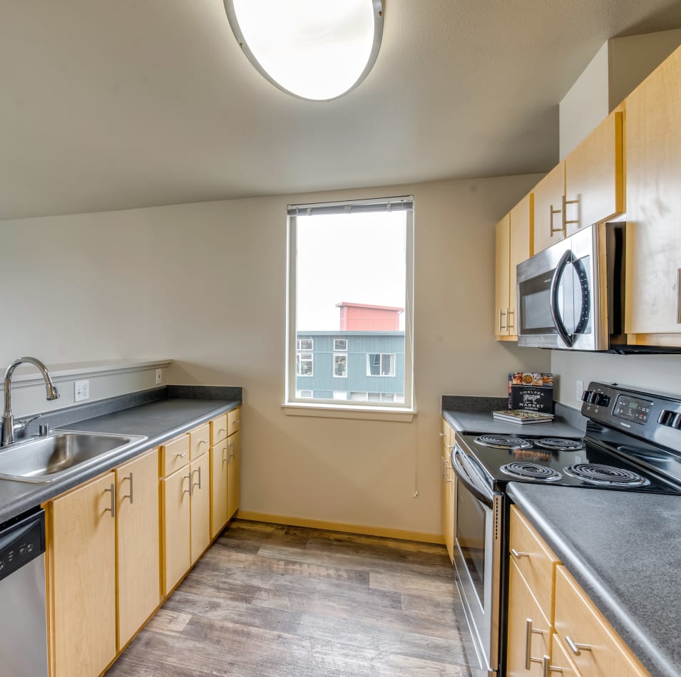 Kitchen with hardwood flooring in a model home at Verse Seattle in Seattle, Washington