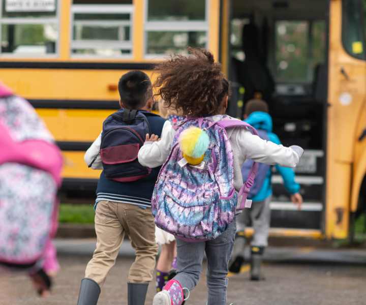 Children boarding their school bus joyfully near Addison Grove in Avon Park, Florida
