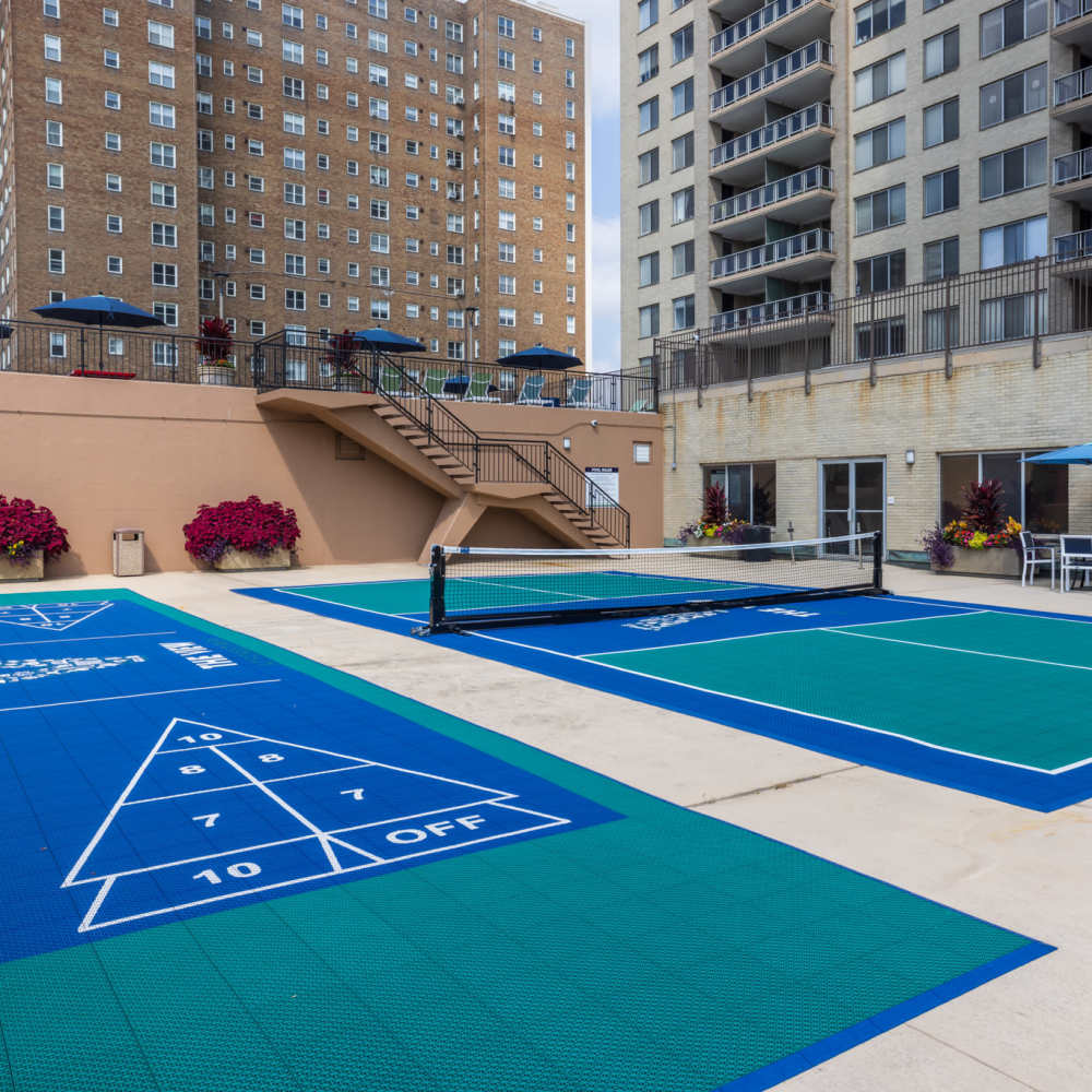 Vibrant outdoor entertainment area featuring well-maintained shuffleboard and tennis courts at The View at Forest Park in St. Louis, Missouri.