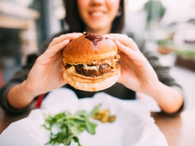 Resident showing off a juicy burger at a restaurant near Creekside at Kenney's Fort in Round Rock, Texas