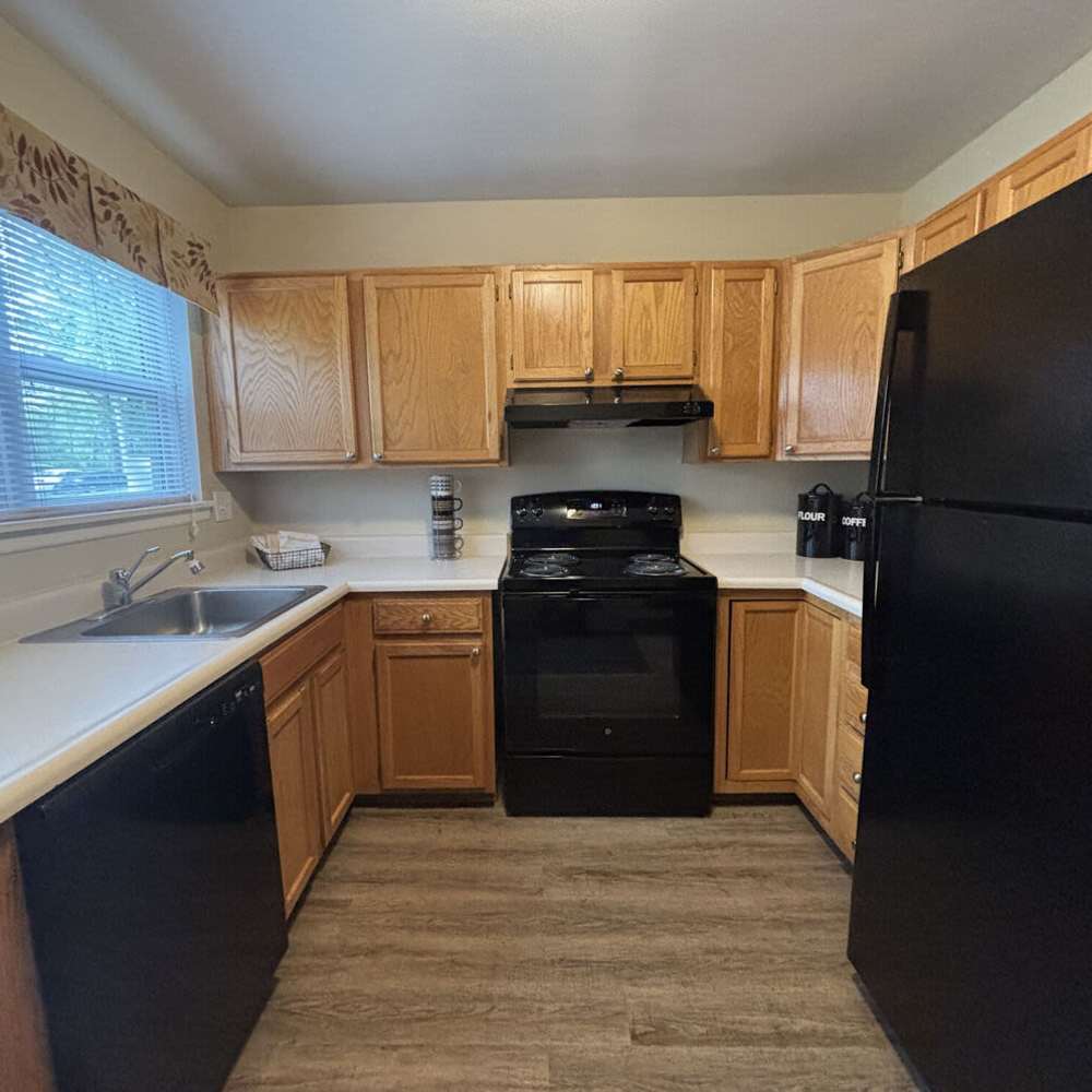 Cozy kitchen with wooden cabinets and modern appliances at Woodland Estates in East Rochester, New York