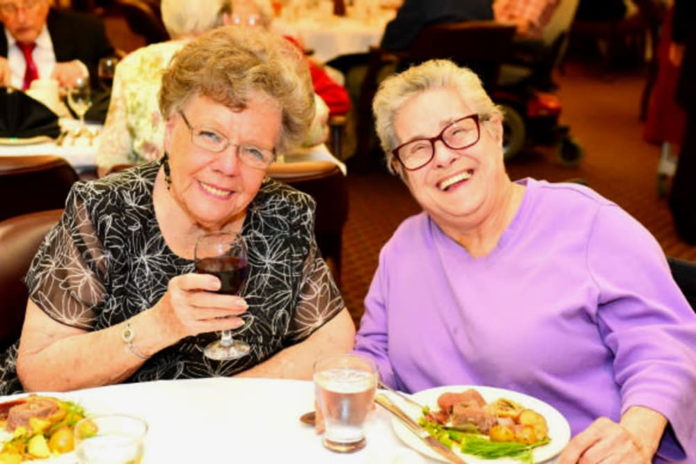 Two residents enjoying a delicious meal at River Commons Senior Living in Redding, California