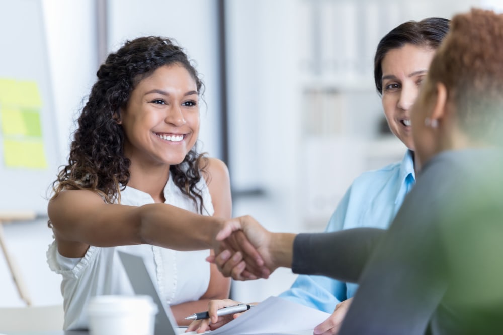 Professional women shaking hands at A-American Self Storage