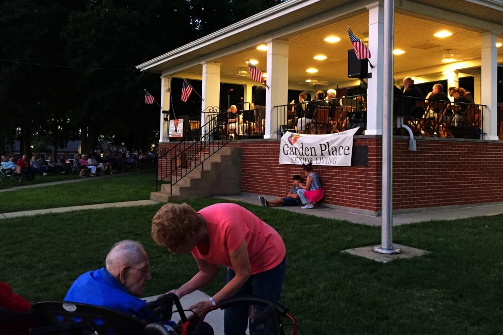 A resident and caregiver enjoying a lawn concert at Garden Place Waterloo in Waterloo, Illinois. 