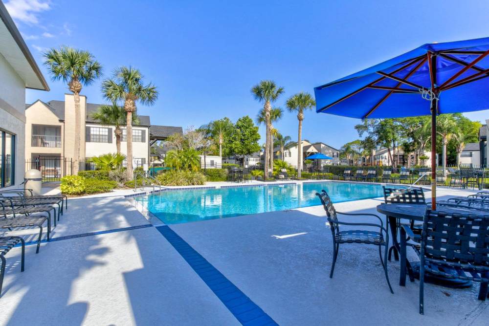 Outdoor pool with seating and umbrellas at Cypress Run in Orlando, Florida