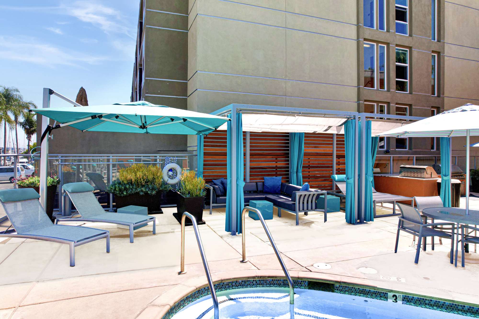 Swimming pool with cabanas at Harborside Marina Bay Apartments in Marina del Rey, California
