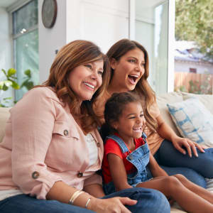 Resident family watching a movie together in the new home at Summit Point Apartments in Mesquite, Texas