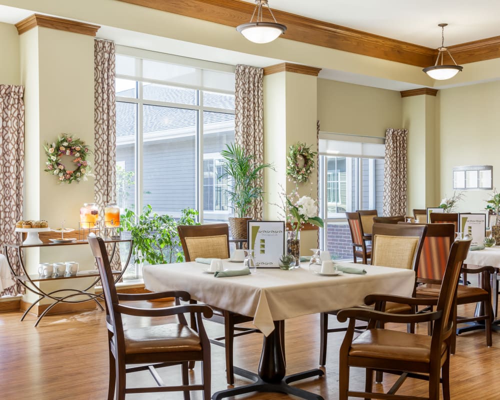 Upscale resident dining room with tall windows and high ceilings at Edencrest at The Legacy in Norwalk, Iowa.