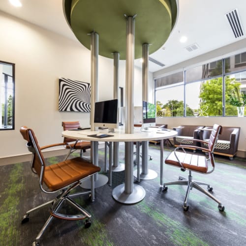Executive business center with multiple workstations in center of room at Marq Uptown in Austin, Texas