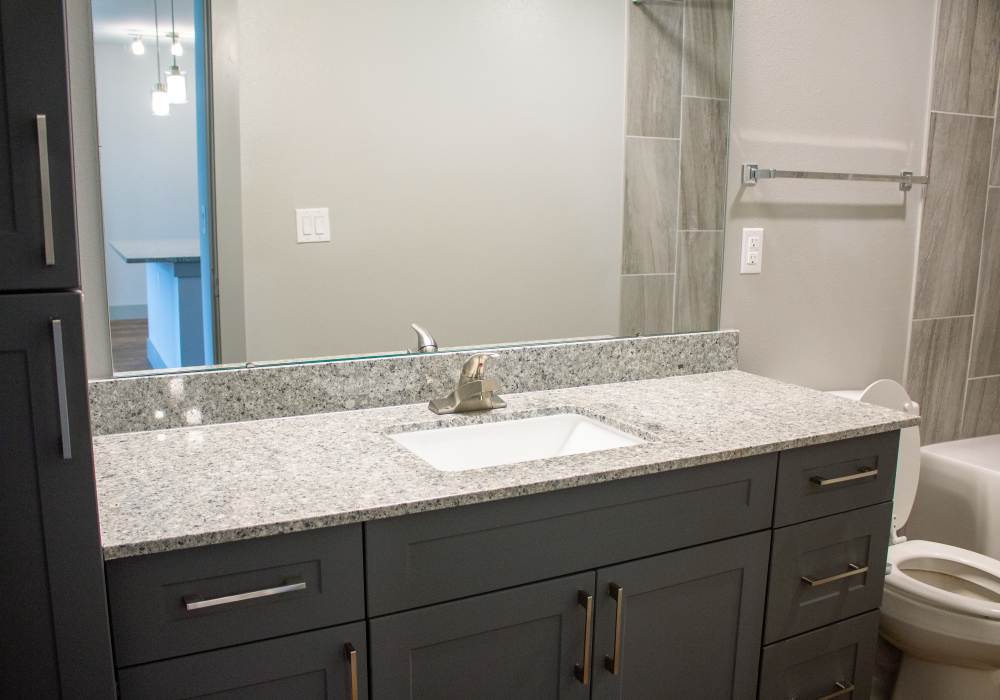 Bright bathroom with mirror and granite countertops at The Bammel in Houston, Texas