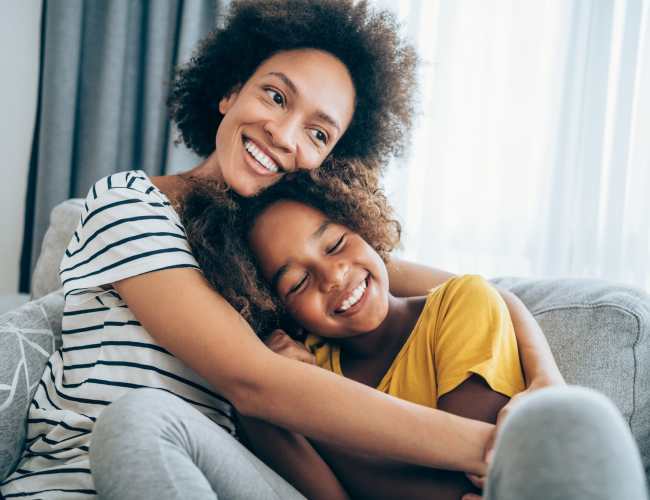 Cozy family moment on a comfy couch with soft lighting at Tesoro Del Valle in Los Angeles, California
