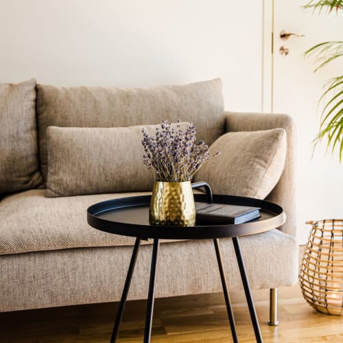 A sofa and side table in a bright living room at Campus Properties in Ames, Iowa