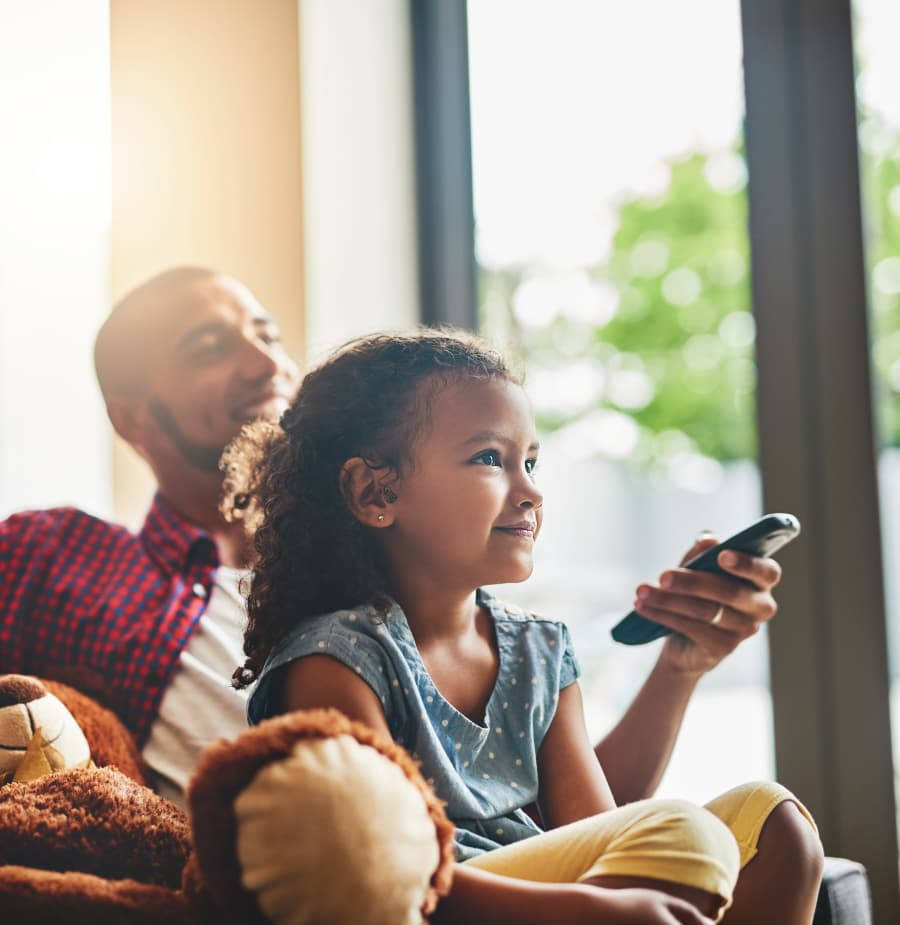 Dad and daughter watching tv at Retreat at Stonecrest in Lithonia, Georgia