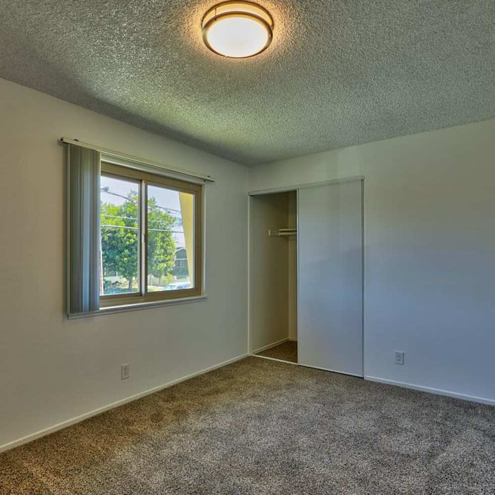 Unfurnished bedroom with large window and closet at Las Lomas Gardens in La Habra, California
