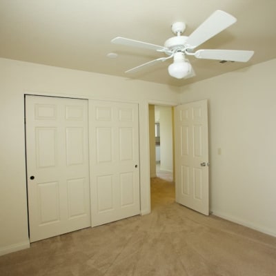 A bedroom with storage and a ceiling fan in a home at South Mesa II in Oceanside, California