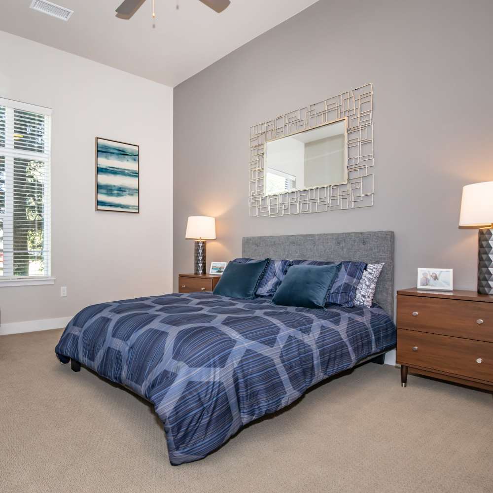 Spacious bedroom with king size bed, side table lamp and ceiling fan at Park Place Olde Town Apartments in Arvada, Colorado