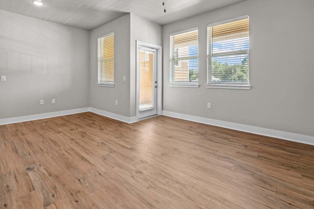 Living room with wood-style flooring at Pebble Brook Apartments in Jacksonville, Texas