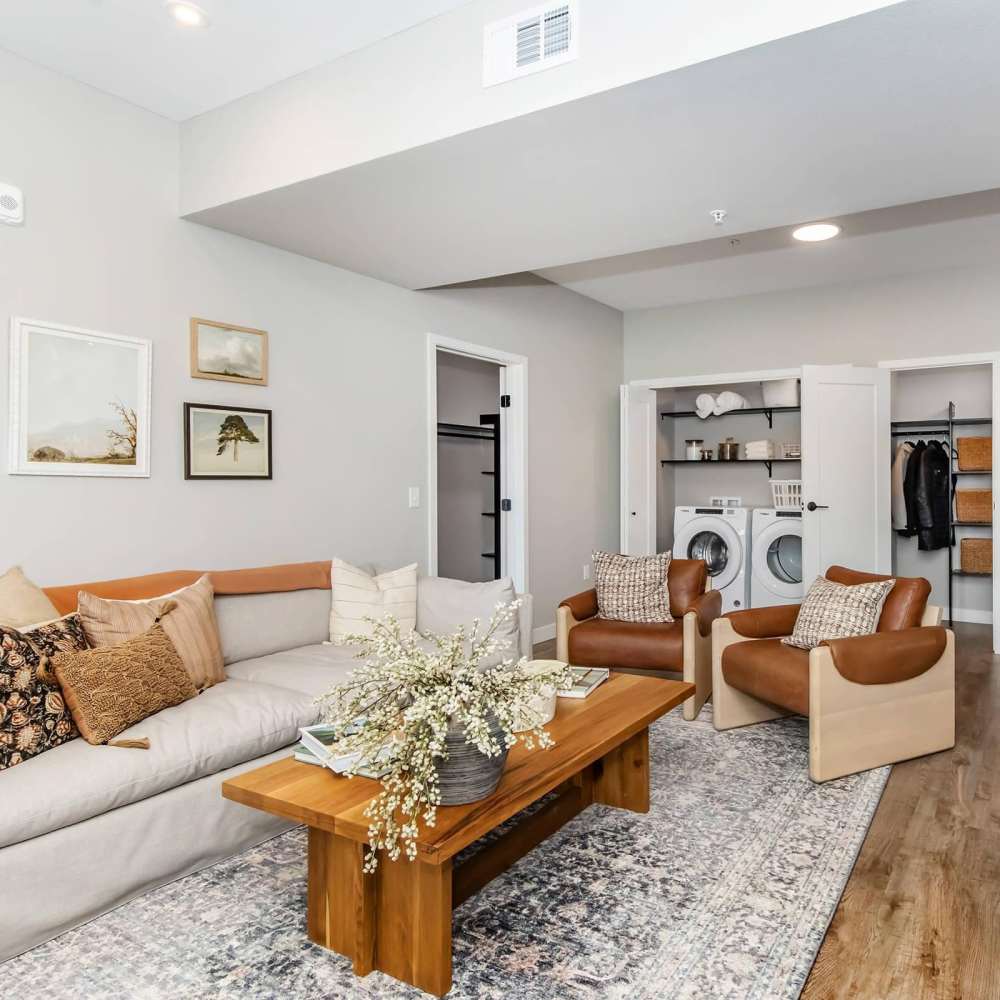 Spacious living room with large couch, chairs, coffee table and wood-style flooring at InterUrban 2.0 in Billings, Montana