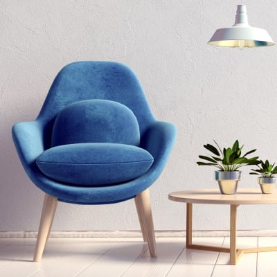 Plants on an end table next to a blue velvet chair in a model home at Sofi Highlands in San Diego, California