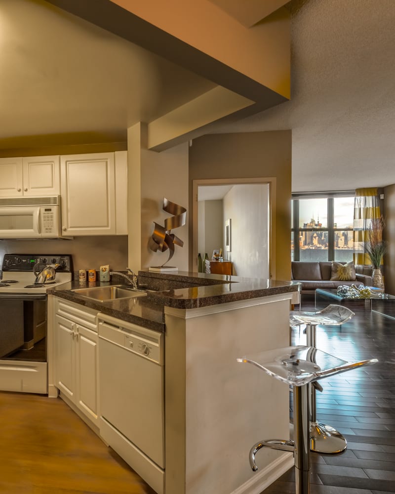 Model kitchen with barstools at Riverbend at Port Imperial in West New York, New Jersey
