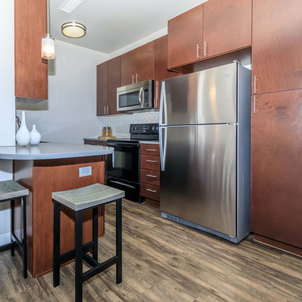 Modern kitchen with stainless-steel appliances and hard wood-style flooring at Park Place Olde Town Apartments in Arvada, Colorado