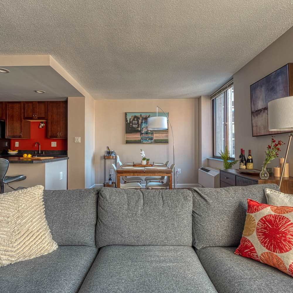 An open and spacious living room with couches adjacent to the kitchen with dining area at Del Coronado Apartments in St. Louis, Missouri Del Coronado Apartments in St. Louis,Missouri