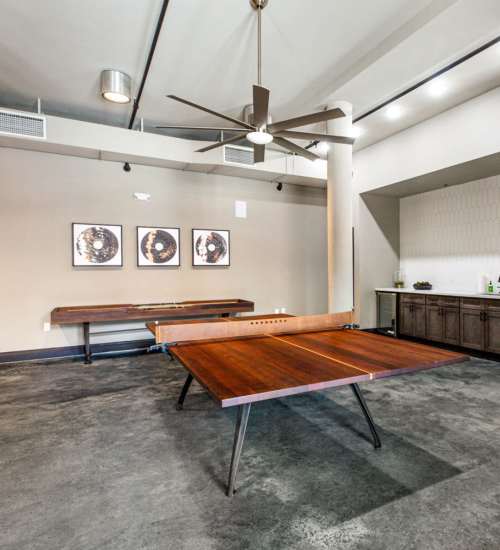 Game room with modern decor and seating at American Can Apartments in New Orleans, Louisiana