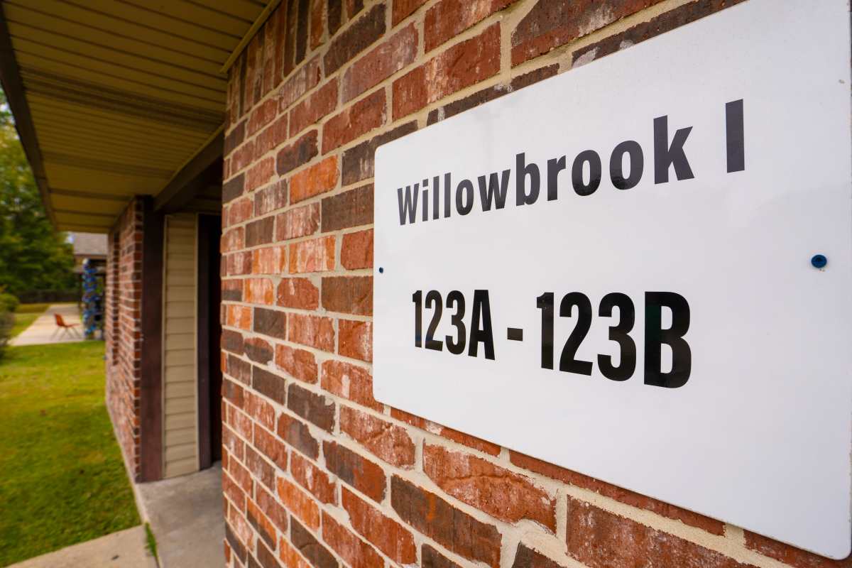 Sign for Willowbrook I apartment community with brick exterior and green landscaping at Willowbrook I in Lafayette, Louisiana 