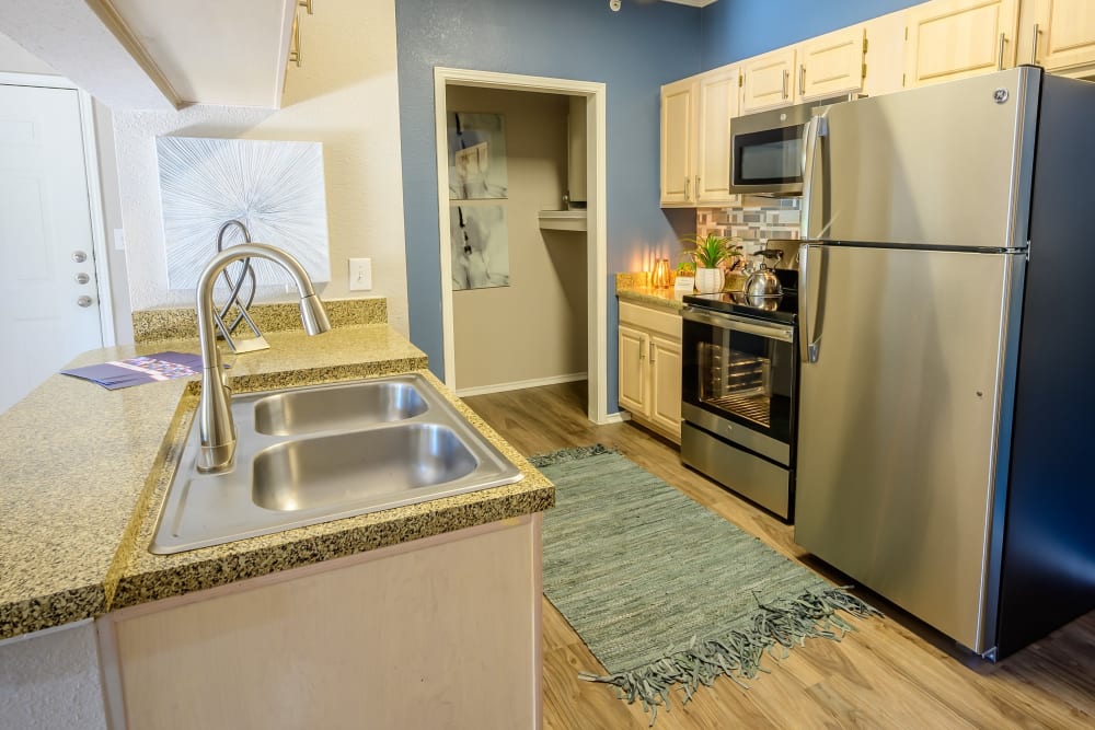 Stainless-steel appliances and granite countertops in a model home's kitchen at 23Hundred @ Ridgeview in Plano, Texas