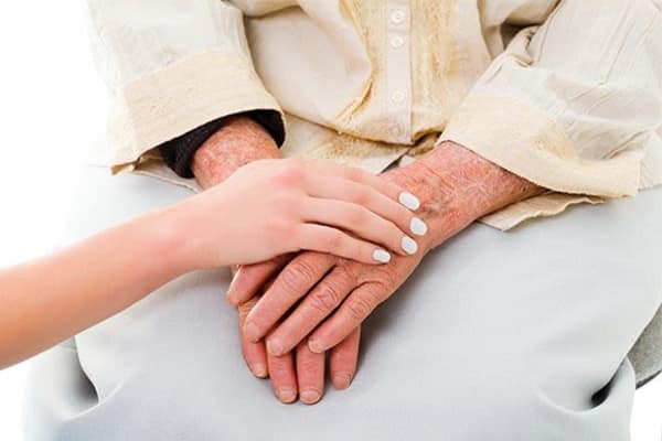 Woman holding hand of senior woman at The Colonial at Historic Camden in Camden, South Carolina