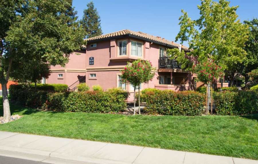 Exterior view of the apartment building with greenery all around at La Vina Apartments in Livermore, California