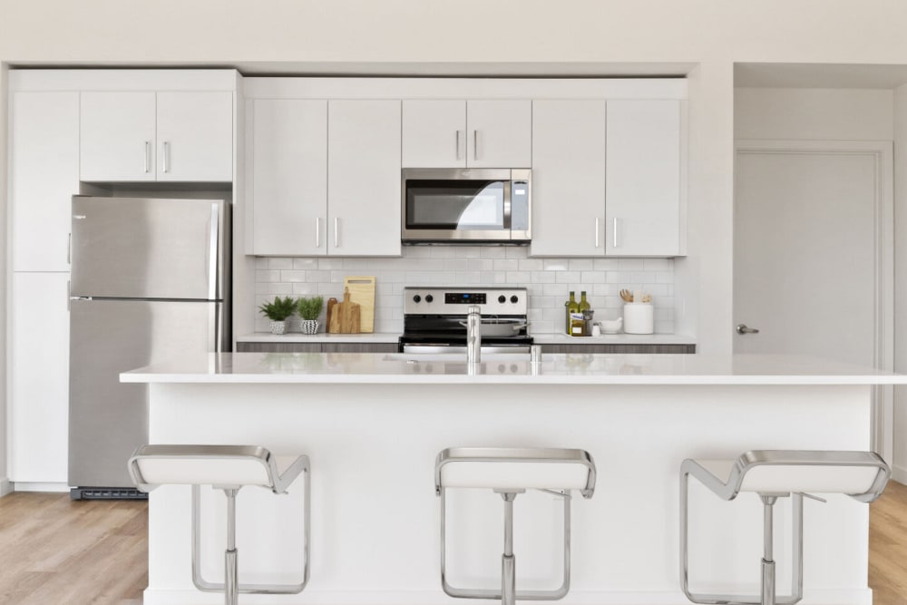 Wood-style flooring and stainless-steel appliances in a kitchen at Lincoln Landing in Hayward, California